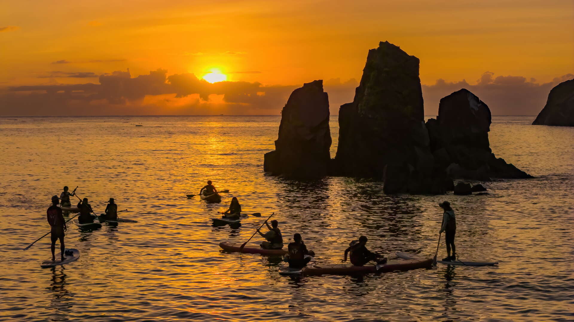 日出時分遊客在海上玩SUP